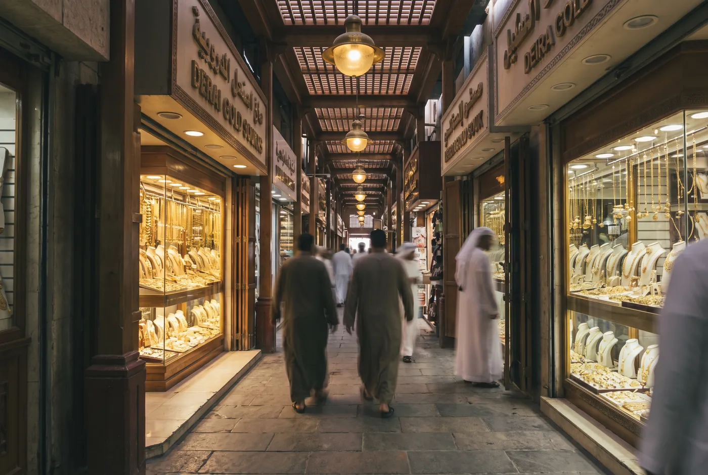 A covered lane of the Deira Gold Souk in old Dubai, jewellers' windows glowing with gold